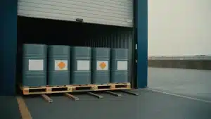A palletized hazmat freight shipment of labeled drums staged at a loading dock for LTL pickup.